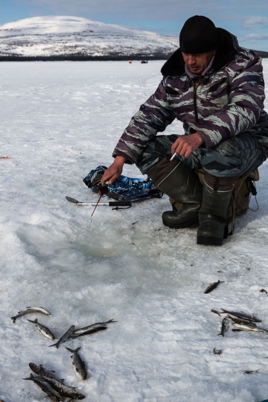 Fishing on the frozen lakes in Artic Russia seems to be a case of a little round hole drilled through the ice with an augar, a tiny plastic fishing rod and line that you jiggle up and down quickly all the time, plenty of smokes and the eskie (cooler bag).  Everyone up here seems to chain smoke!